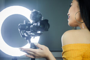 Influencer speaking to camera, lit by a ring light