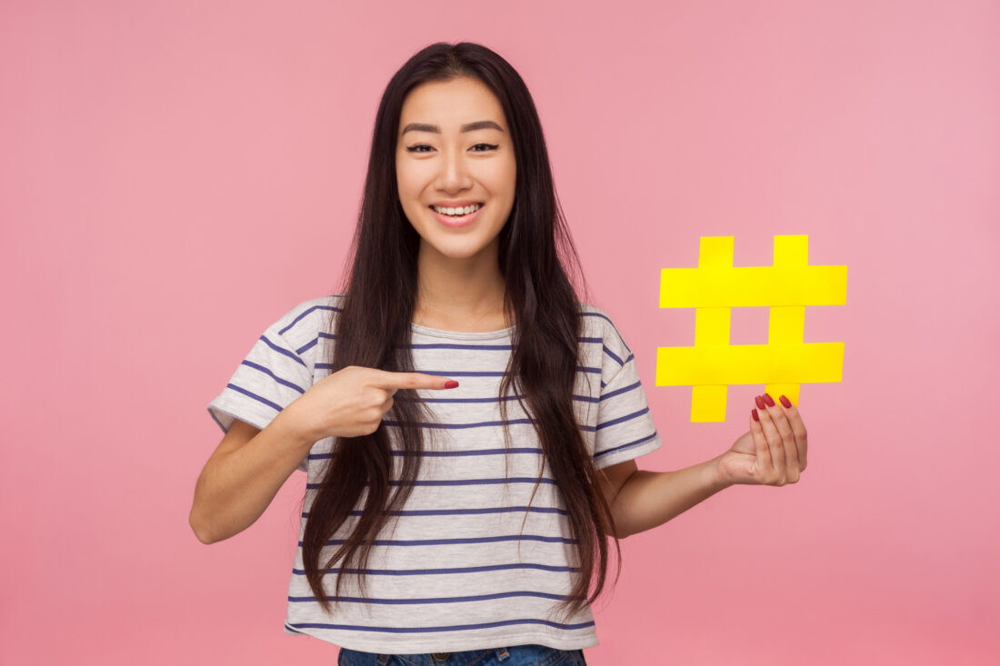 Woman holding hashtag cut out