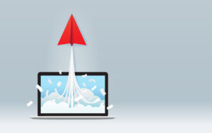 Red paper plane launching from laptop screen on grey background